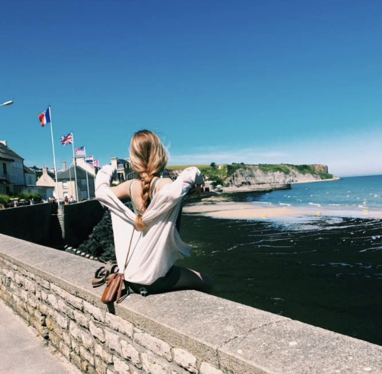 Girl sitting in front of beach on English channel in France
