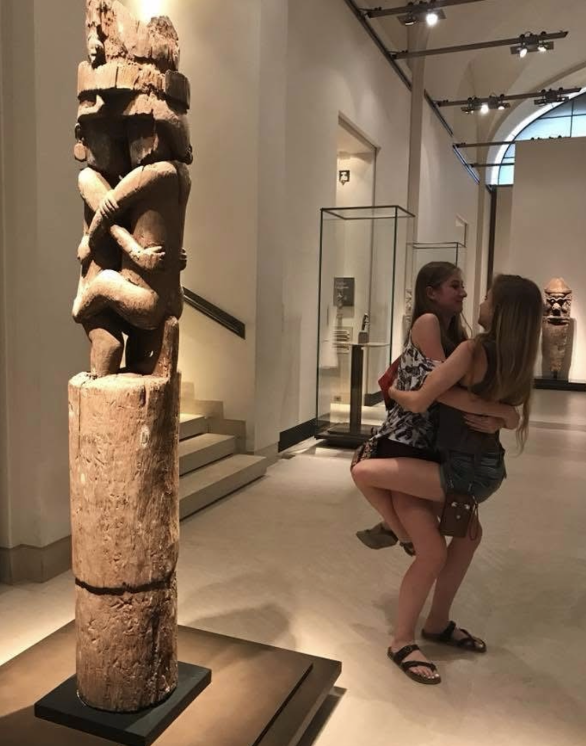 2 girls posing in front of a statue in the Louvre